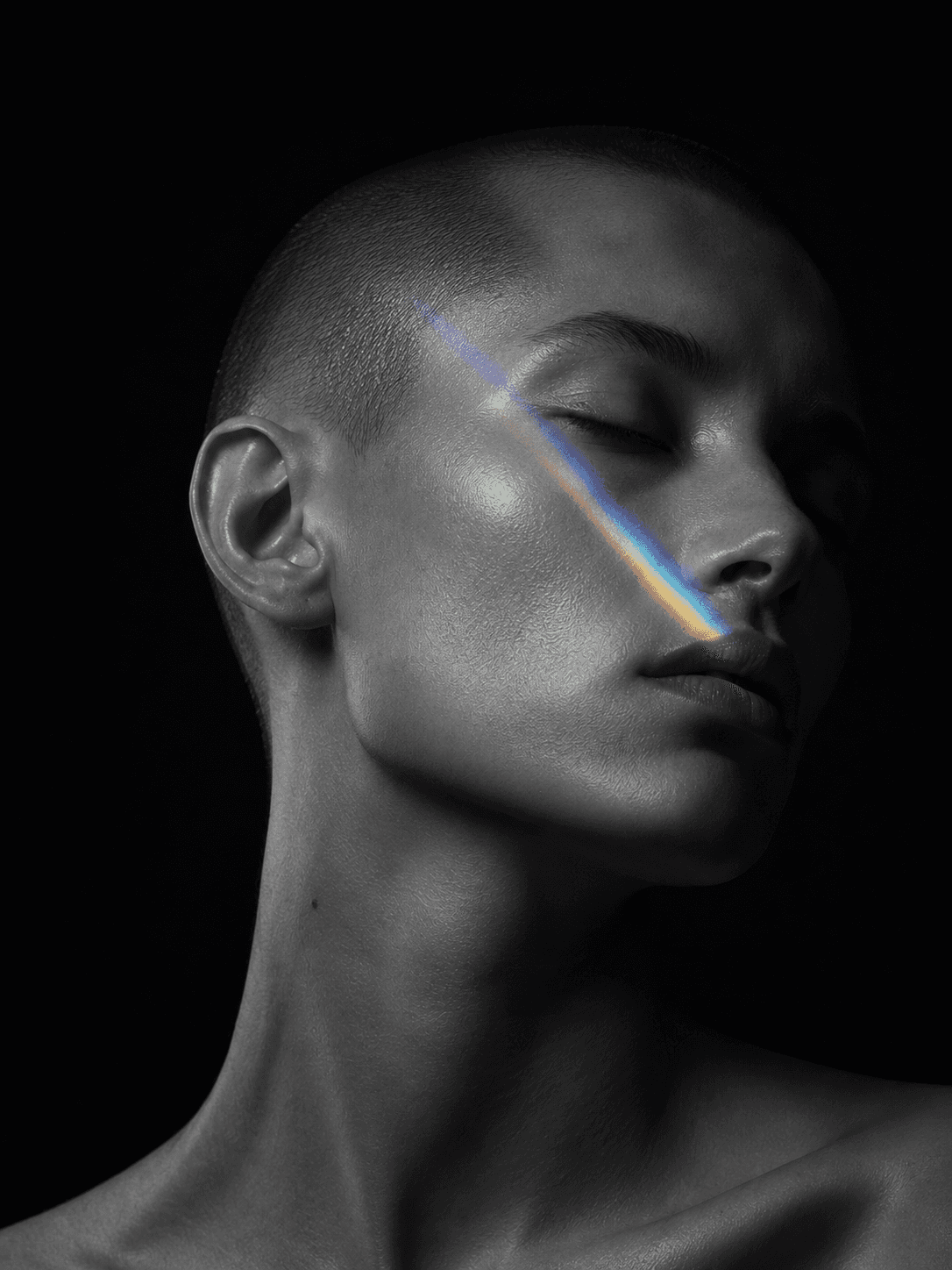 Portrait en noir et blanc traversé par un fin faisceau de lumière prismatique.
